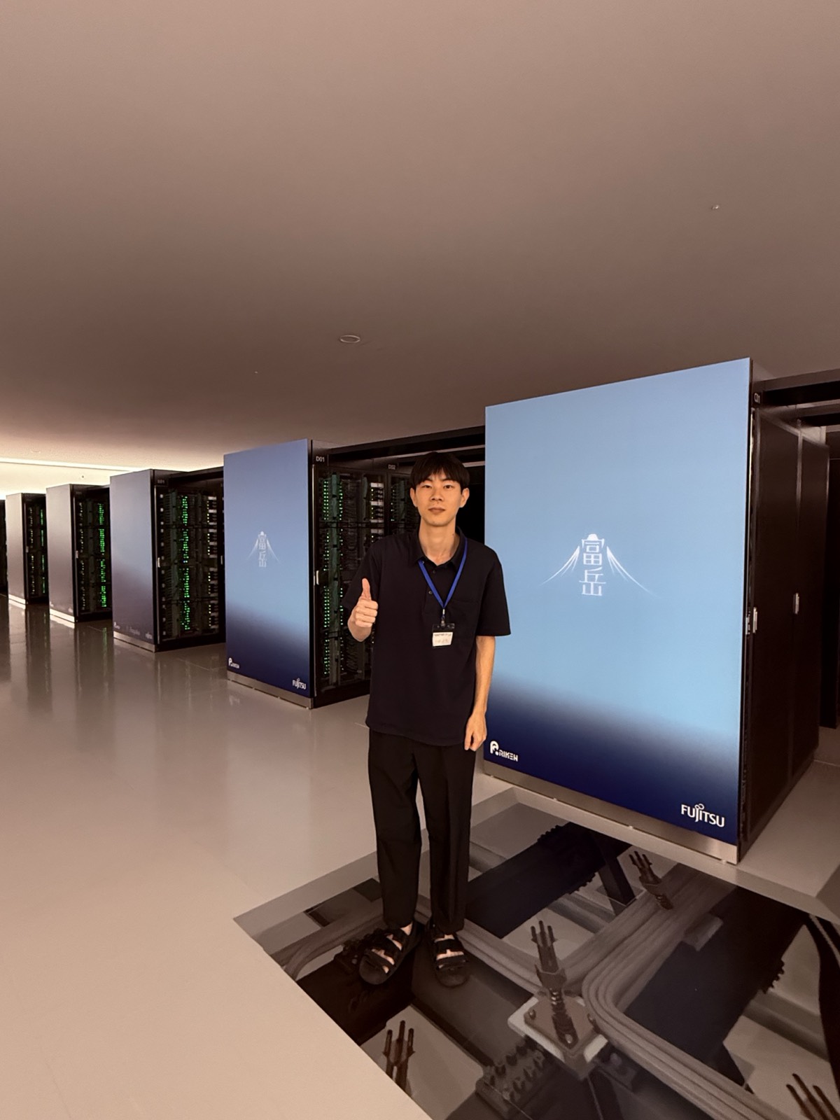 Yuto Akimoto in front of the Fugaku supercomputer at RIKEN